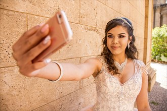 Smiling Hispanic girl posing for cell phone selfie
