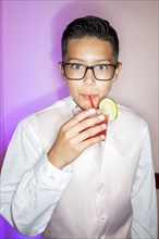 Hispanic boy drinking beverage with a straw