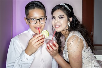 Hispanic boy and girl drinking beverages with straws