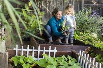 Caucasian mother teaching gardening to daughter