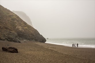 Distant people running on beach