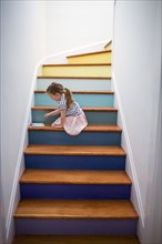 Caucasian girl using digital tablet on multicolor staircase