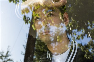 Serious Chinese man leaning on window