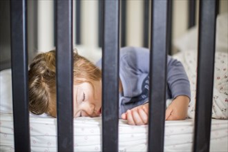 Caucasian baby girl sleeping in crib
