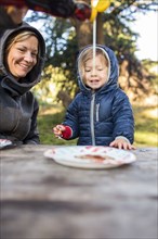 Caucasian mother pouring syrup on pancake for daughter