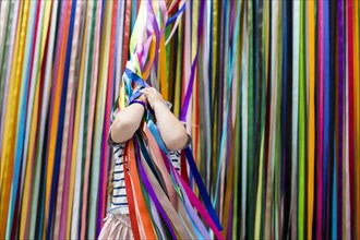 Caucasian girl playing with colorful hanging streamers