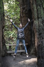 Caucasian woman jumping for joy in forest