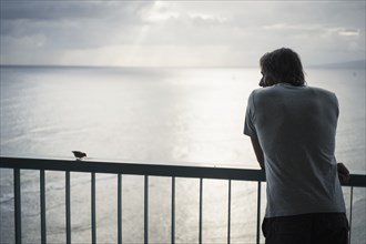 Caucasian man admiring ocean view from railing