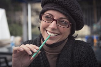 Close up of smiling Caucasian woman holding pencil