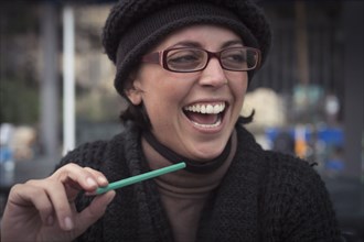 Close up of laughing Caucasian woman holding pencil