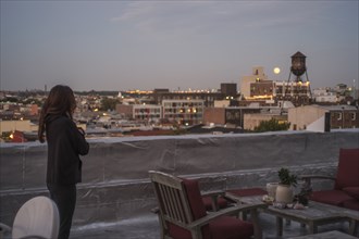 Caucasian woman admiring cityscape from urban rooftop
