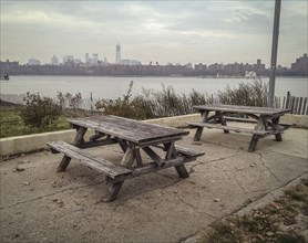Empty picnic tables in urban park at waterfront