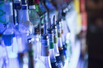 Close up of liquor bottles illuminated at bar
