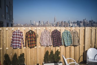 Flannel shirts hanging to dry in urban backyard