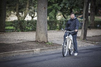 Caucasian man riding bicycle on street