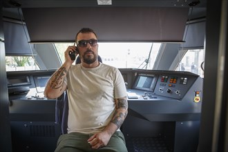 Caucasian man talking on cell phone in command center