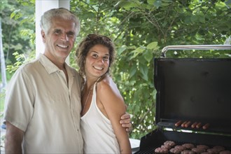 Caucasian father and daughter grilling in backyard