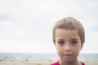 Caucasian boy with serious expression on beach