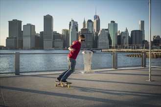 Caucasian skateboarder doing trick at waterfront