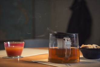 Steaming pot of tea on table