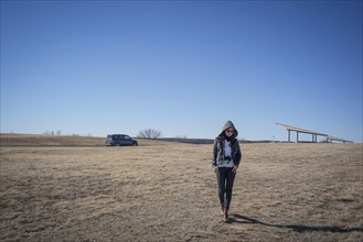 Caucasian woman walking in empty field