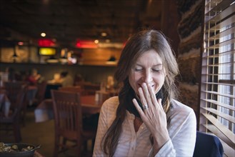 Caucasian woman laughing in bar