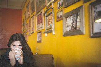 Caucasian woman drinking coffee in cafe