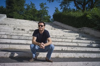Caucasian man sitting on staircase outdoors