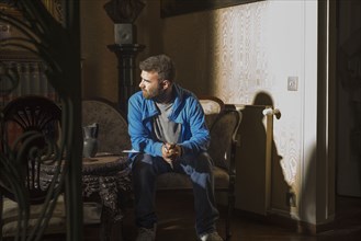 Caucasian man sitting in sunlight in living room