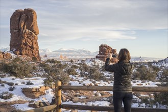 Caucasian woman photographing rock formations in landscape