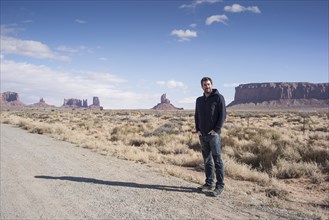 Caucasian man standing on desert dirt road
