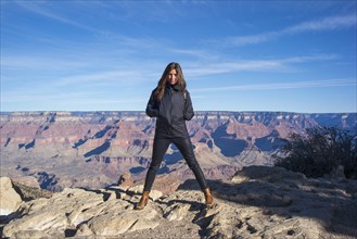 Caucasian woman standing over Grand Canyon