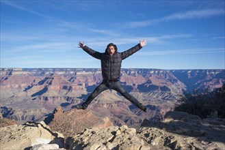 Caucasian man jumping at Grand Canyon