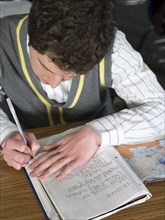 Student writing at desk in classroom