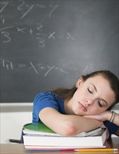 Bored student sleeping at desk in classroom