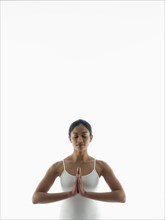 Serene woman meditating with hands clasped