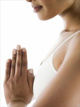 Close up of serene woman meditating with hands clasped