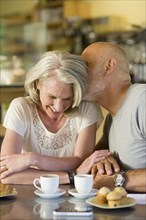 Older couple kissing in cafe
