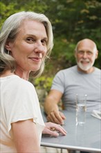 Older couple sitting at table outdoors