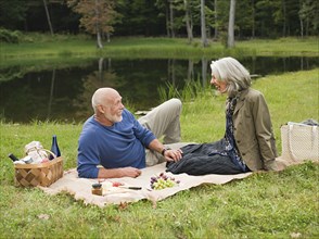 Older couple relaxing at picnic in park