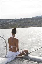 Woman admiring ocean from sailboat deck