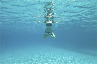 Underwater view of woman swimming in ocean