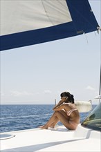 Woman sunbathing on sailboat deck