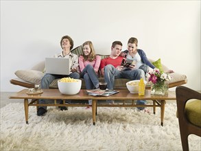 Friends relaxing on sofa in living room