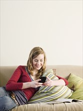 Caucasian woman using cell phone on sofa