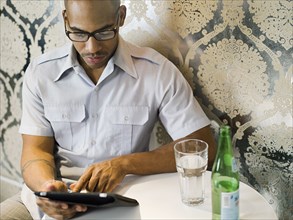 African American man using digital tablet in restaurant