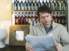 Caucasian businessman reading newspaper in cafe