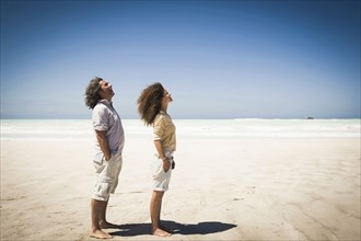 Couple standing in wind on beach