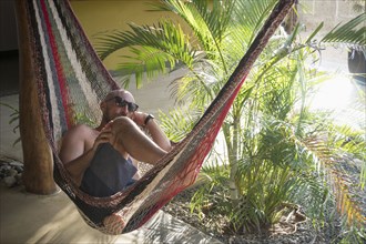 Caucasian man relaxing in hammock