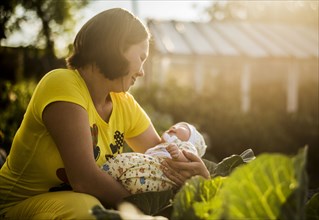Caucasian mother holding baby girl in garden
